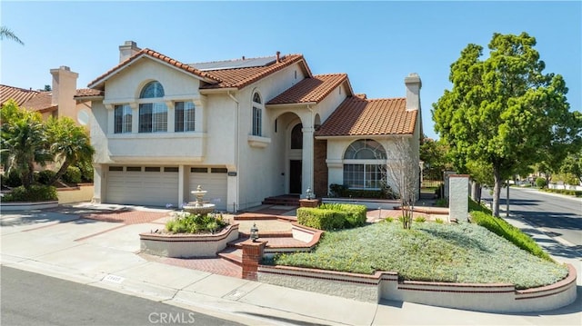 20485 Via Canarias, Yorba Linda, CA 92887 - mediterranean / spanish-style house with concrete driveway, an attached garage, solar panels, stucco siding, and a tiled roof