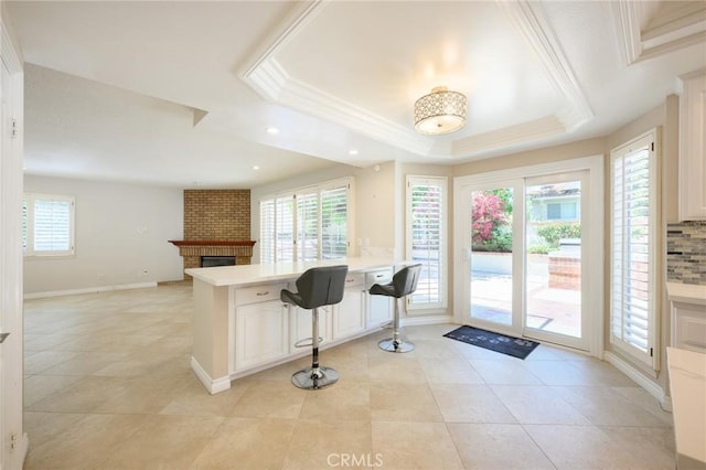20485 Via Canarias, Yorba Linda, CA 92887 - kitchen featuring a tray ceiling, light countertops, a fireplace, a peninsula, and open floor plan