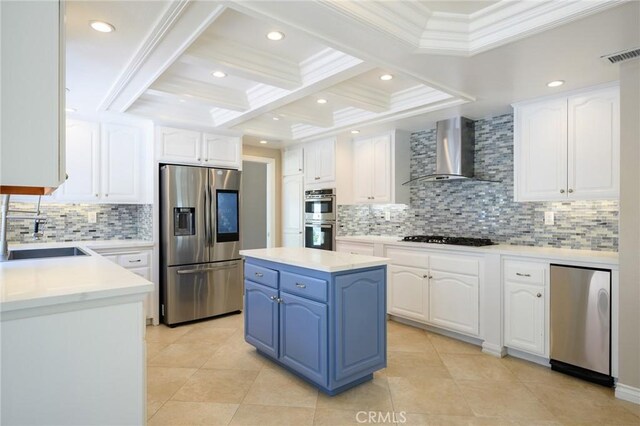 20485 Via Canarias, Yorba Linda, CA 92887 - kitchen with stainless steel appliances, wall chimney range hood, blue cabinetry, white cabinets, and ornamental molding