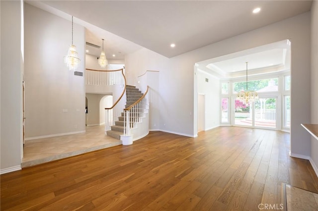 20485 Via Canarias, Yorba Linda, CA 92887 - unfurnished living room featuring a chandelier, wood-type flooring, stairway, a tray ceiling, and recessed lighting