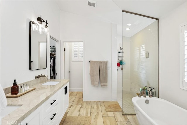 2294 Pacific Ave, Costa Mesa, CA 92627 - full bathroom with a soaking tub, double vanity, a tile shower, a walk in closet, and recessed lighting
