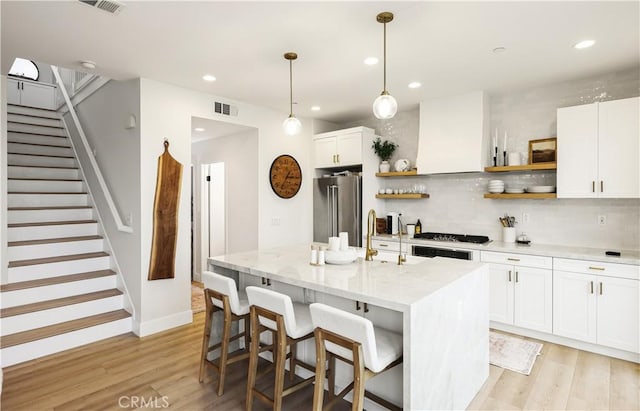 2294 Pacific Ave, Costa Mesa, CA 92627 - kitchen with stainless steel appliances, open shelves, wall chimney range hood, light wood-style floors, and recessed lighting