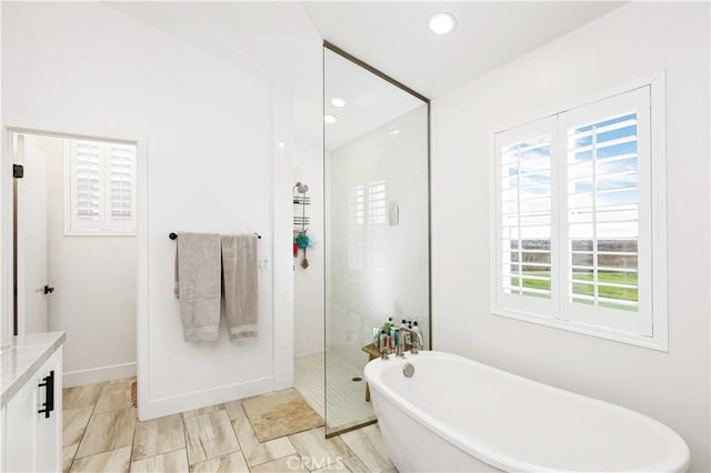 2294 Pacific Ave, Costa Mesa, CA 92627 - bathroom featuring a freestanding tub, a walk in shower, vanity, recessed lighting, and baseboards