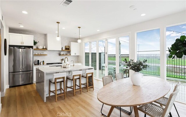 2294 Pacific Ave, Costa Mesa, CA 92627 - kitchen featuring freestanding refrigerator, open shelves, a center island with sink, light countertops, and recessed lighting