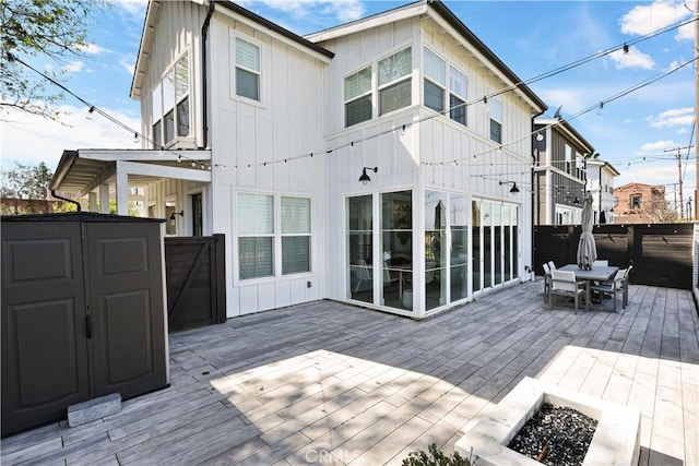 2294 Pacific Ave, Costa Mesa, CA 92627 - rear view of house featuring a fire pit, board and batten siding, a wooden deck, and outdoor dining space