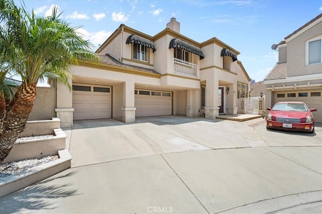 1506 Bergman Ct, Brea, CA 92821 - mediterranean / spanish-style house with concrete driveway, a garage, stucco siding, a balcony, and a chimney