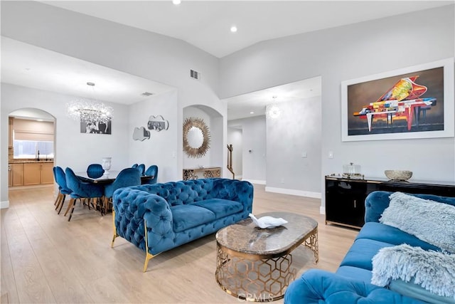 13909 Mountain View Pl, Sylmar, CA 91342 - living area with arched walkways, a chandelier, light wood-style floors, recessed lighting, and vaulted ceiling
