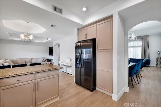 13909 Mountain View Pl, Sylmar, CA 91342 - kitchen with black fridge with ice dispenser, arched walkways, a tray ceiling, open floor plan, and a chandelier