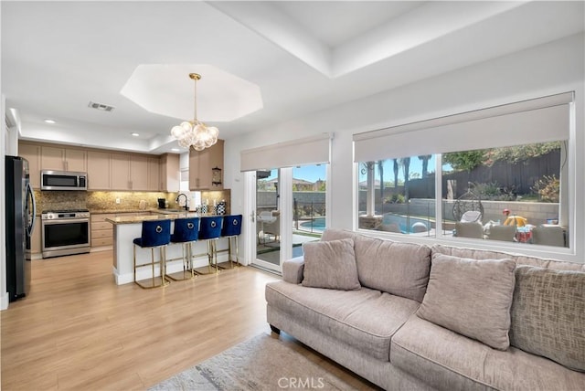 13909 Mountain View Pl, Sylmar, CA 91342 - living area featuring a tray ceiling, light wood-style floors, recessed lighting, and a chandelier