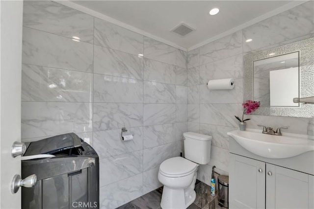 13909 Mountain View Pl, Sylmar, CA 91342 - bathroom with washer / dryer, vanity, toilet, and tile walls