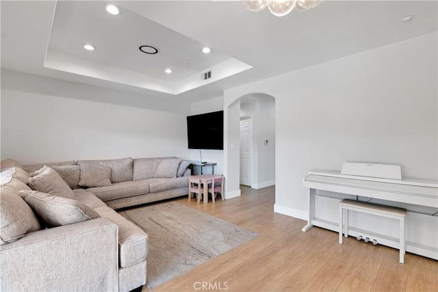13909 Mountain View Pl, Sylmar, CA 91342 - living area featuring arched walkways, a raised ceiling, recessed lighting, light wood finished floors, and baseboards