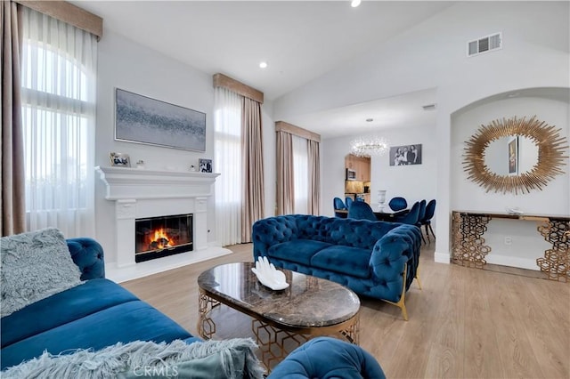 13909 Mountain View Pl, Sylmar, CA 91342 - living area featuring a chandelier, wood finished floors, lofted ceiling, a glass covered fireplace, and recessed lighting