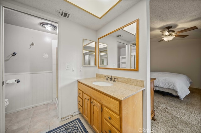 802 Duval St, La Verne, CA 91750 - bathroom featuring vanity, toilet, wainscoting, a textured ceiling, and a shower