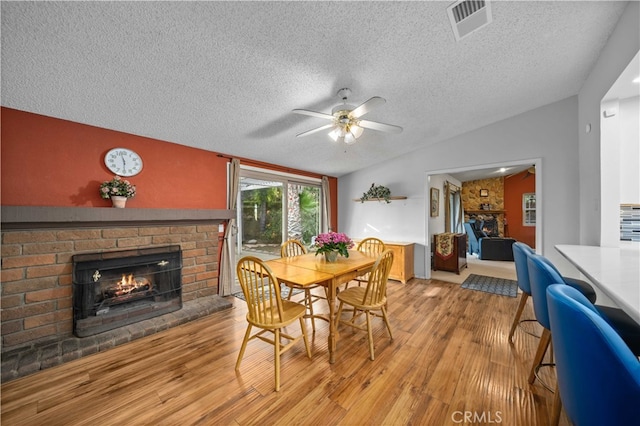 802 Duval St, La Verne, CA 91750 - dining space with a brick fireplace, lofted ceiling, a textured ceiling, light wood-style flooring, and ceiling fan