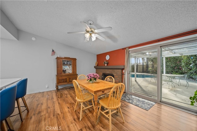 802 Duval St, La Verne, CA 91750 - dining room with vaulted ceiling, a textured ceiling, ceiling fan, wood finished floors, and a fireplace