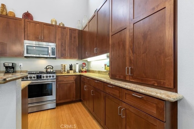 223 San Miguel St, Avila Beach, CA 93424 - kitchen with stainless steel appliances, light stone countertops, and light wood-style flooring