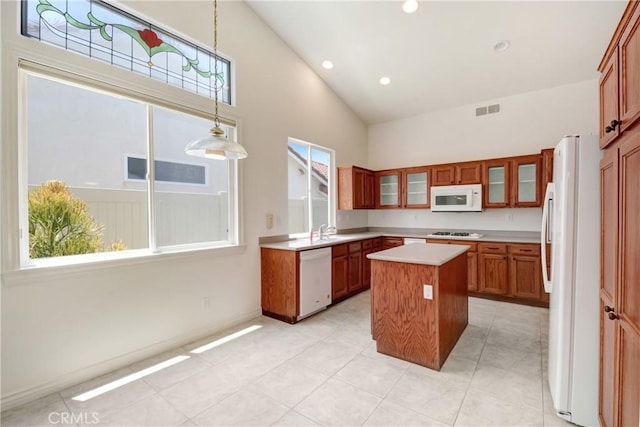 39654 Bordeaux Pl, Murrieta, CA 92562 - kitchen featuring white appliances, high vaulted ceiling, a kitchen island, brown cabinetry, and light countertops
