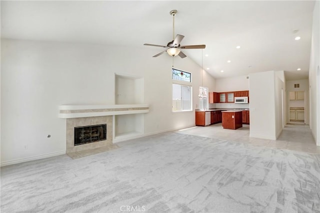 39654 Bordeaux Pl, Murrieta, CA 92562 - unfurnished living room featuring light colored carpet, ceiling fan, a tiled fireplace, baseboards, and recessed lighting