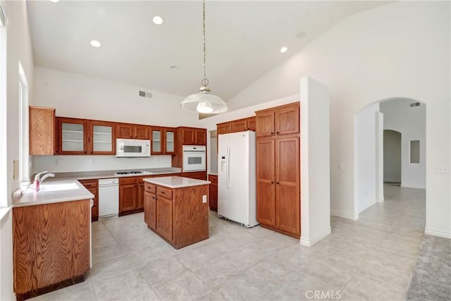 39654 Bordeaux Pl, Murrieta, CA 92562 - kitchen featuring white appliances, a sink, arched walkways, light countertops, and a kitchen island