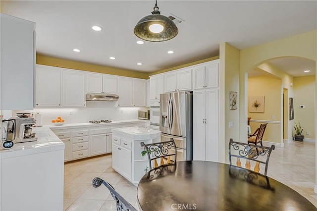11771 Coorsgold Ln, Porter Ranch, CA 91326 - kitchen with appliances with stainless steel finishes, arched walkways, tile countertops, under cabinet range hood, and light tile patterned floors