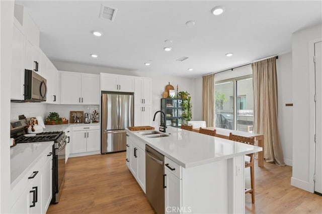 3590 E Peckham Paseo Unit 6, Ontario, CA 91761 - kitchen featuring stainless steel appliances, a breakfast bar area, tasteful backsplash, light countertops, and recessed lighting