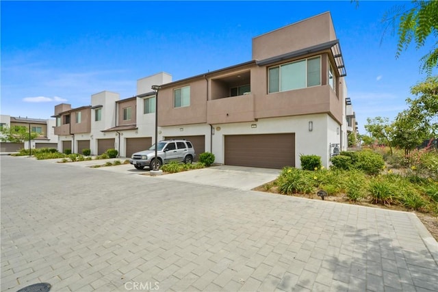 3590 E Peckham Paseo Unit 6, Ontario, CA 91761 - view of front of home featuring an attached garage, driveway, stucco siding, and a residential view