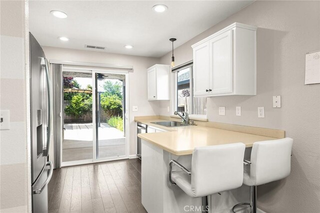 1377 Lucy Way, Chico, CA 95973 - kitchen with a sink, a peninsula, light countertops, a kitchen bar, and appliances with stainless steel finishes