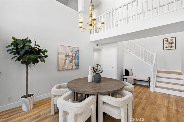 431 Cranston Ct Unit 102, Long Beach, CA 90803 - dining room with stairs, a chandelier, light wood-type flooring, and a high ceiling