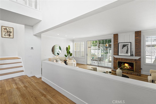 431 Cranston Ct Unit 102, Long Beach, CA 90803 - living room featuring wood finished floors, a brick fireplace, stairs, ornamental molding, and recessed lighting