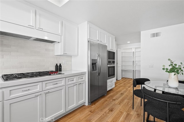 431 Cranston Ct Unit 102, Long Beach, CA 90803 - kitchen featuring stainless steel appliances, light countertops, white cabinetry, decorative backsplash, and light wood-style flooring