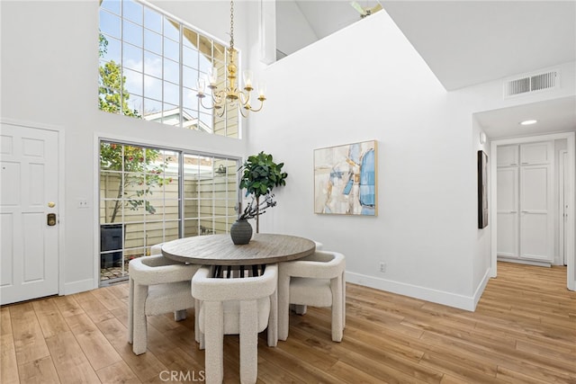 431 Cranston Ct Unit 102, Long Beach, CA 90803 - dining area featuring a towering ceiling, a chandelier, and light wood-style flooring