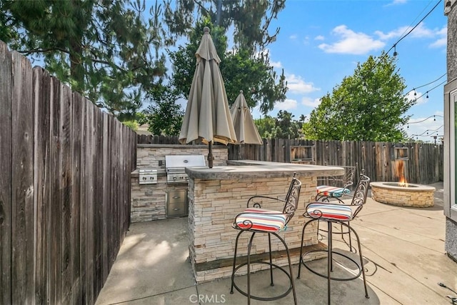 27692 Motherlode Ct, Laguna Niguel, CA 92677 - fenced backyard featuring an outdoor kitchen, a fire pit, exterior bar, and a patio