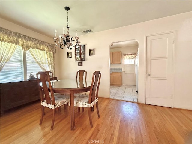 1444 N Maple St, Burbank, CA 91505 - dining room featuring a chandelier, arched walkways, and light wood-style flooring