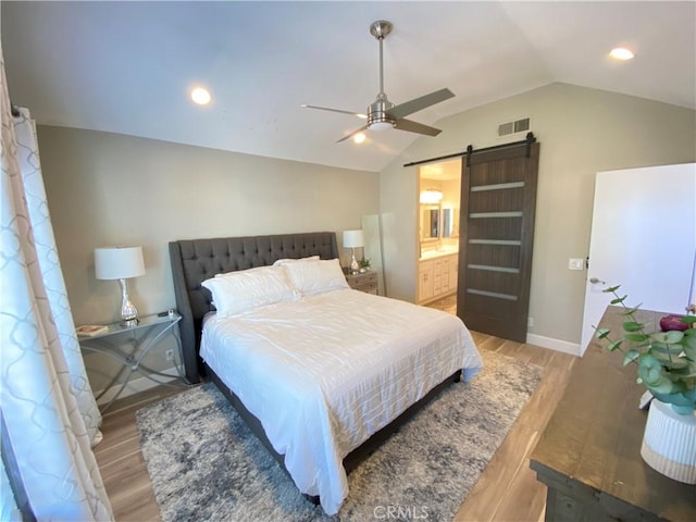 1225 Lima Cir Unit 18, Placentia, CA 92870 - bedroom with a barn door, vaulted ceiling, light wood-type flooring, a ceiling fan, and ensuite bathroom