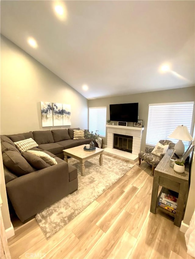 1225 Lima Cir Unit 18, Placentia, CA 92870 - living area with light wood-style flooring, lofted ceiling, a fireplace, healthy amount of natural light, and recessed lighting