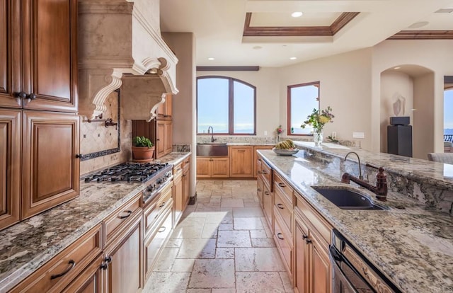 7133 Obelisco Cir, Carlsbad, CA 92009 - kitchen featuring stone tile floors, a sink, stainless steel gas cooktop, a tray ceiling, and crown molding