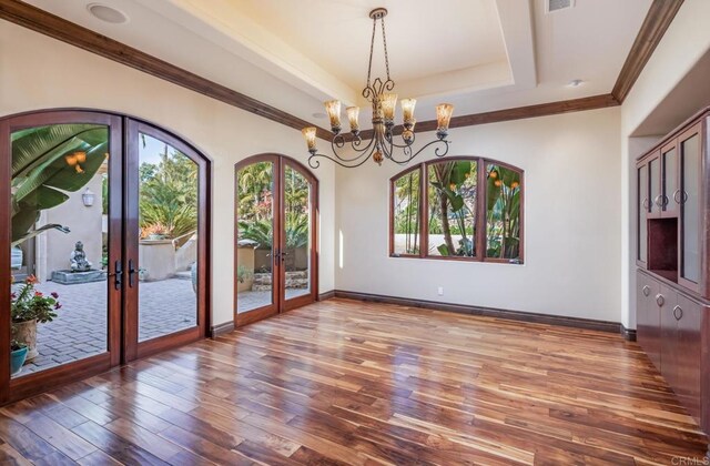 7133 Obelisco Cir, Carlsbad, CA 92009 - spare room with french doors, a tray ceiling, wood finished floors, a chandelier, and baseboards