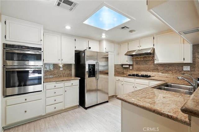 19401 Twin Hills Pl, Porter Ranch, CA 91326 - kitchen with stainless steel appliances, under cabinet range hood, decorative backsplash, white cabinets, and recessed lighting