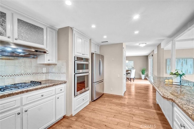 4144 Rainwood Ave, Yorba Linda, CA 92886 - kitchen with stainless steel appliances, white cabinets, backsplash, under cabinet range hood, and light wood finished floors