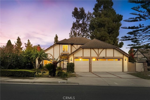 4144 Rainwood Ave, Yorba Linda, CA 92886 - tudor house with stucco siding, a garage, driveway, and a chimney