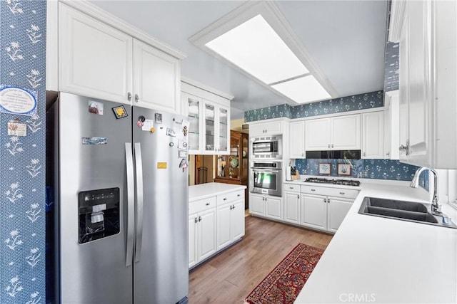 19302 Maynard Way N, Tustin, CA 92705 - kitchen with stainless steel appliances, light wood-style floors, white cabinets, and light countertops