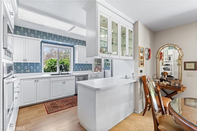 19302 Maynard Way N, Tustin, CA 92705 - kitchen with appliances with stainless steel finishes, a peninsula, white cabinets, light countertops, and wallpapered walls