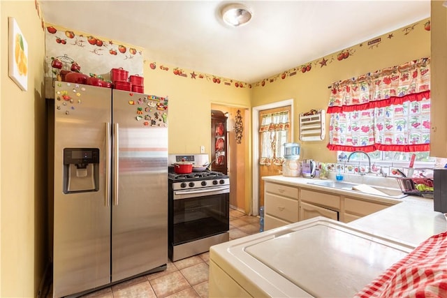 10752 Weigand Ave, Los Angeles, CA 90059 - kitchen featuring appliances with stainless steel finishes, light countertops, a sink, and light tile patterned flooring