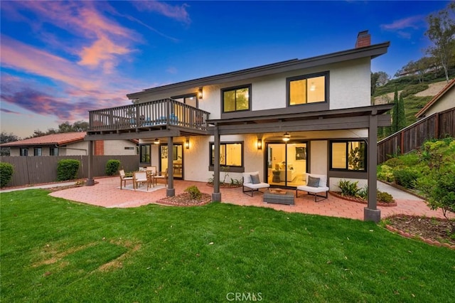 2959 Butler St, Oceanside, CA 92054 - back of house at dusk featuring a chimney, a patio area, a fire pit, stucco siding, and a deck