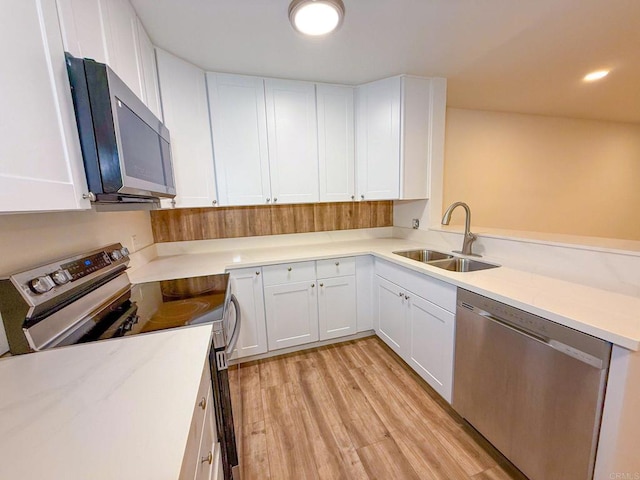 166 N 1st St Unit 18, El Cajon, CA 92021 - kitchen featuring appliances with stainless steel finishes, a sink, light wood finished floors, and white cabinetry