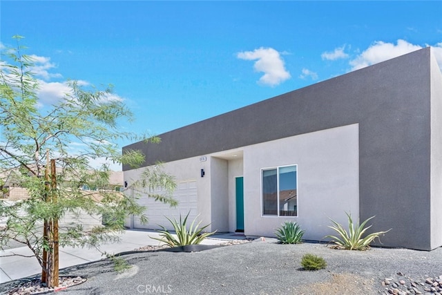 13176 Quinta Way, Desert Hot Springs, CA 92240 - view of front facade featuring stucco siding, a garage, and concrete driveway