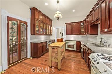 225 N Lima St, Sierra Madre, CA 91024 - kitchen with oven, a sink, glass insert cabinets, light wood finished floors, and recessed lighting