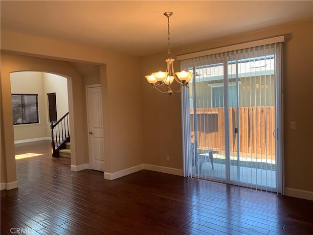 538 Burnt Ranch Way, Chico, CA 95973 - spare room featuring arched walkways, dark wood finished floors, a chandelier, and stairs