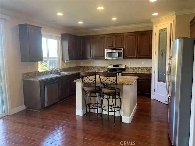 538 Burnt Ranch Way, Chico, CA 95973 - kitchen with stainless steel appliances, a center island, a breakfast bar, dark wood finished floors, and ornamental molding