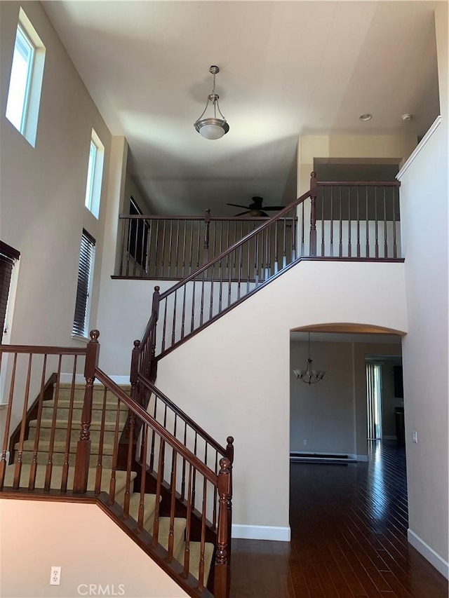 538 Burnt Ranch Way, Chico, CA 95973 - stairway featuring a ceiling fan, a towering ceiling, wood-type flooring, a chandelier, and a baseboard radiator